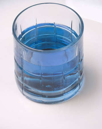 A beverage of deep blue water in a small glass. Could be used as alcoholic, non-alcoholic, or pure water beverage.の写真素材