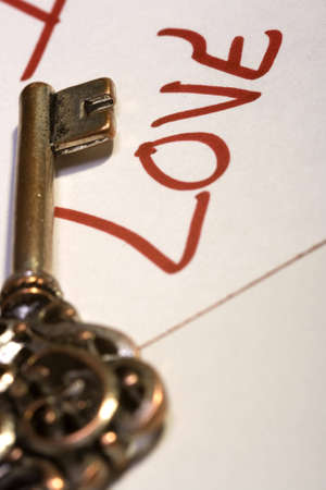 An antique skeleton key above the word love on a love noteの写真素材