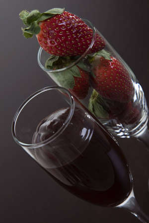 Two champagne glasses, one with strawberries and one with chocolate syrup. Conotation of romance.の写真素材