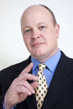 Balding businessman gesturing with hand の写真素材