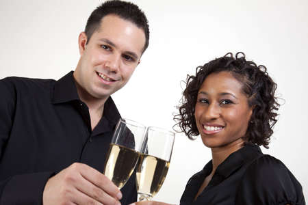An interracial couple toasting with champagneの写真素材