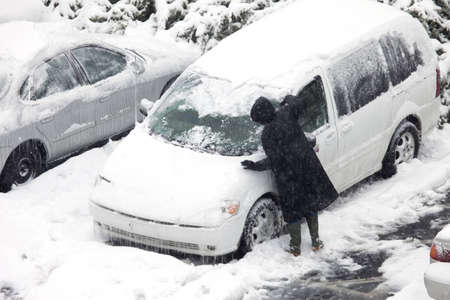 A person scraping snow and ice during the ice storm in Louisville, Kentuckyの写真素材