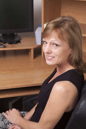 A female office worker sitting at her desk. の写真素材