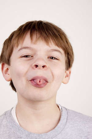 Young boy sticking his tongue out at the camera.の写真素材