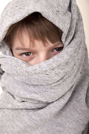 Headshot of a young boy in tribal headdress of cental asiaの写真素材