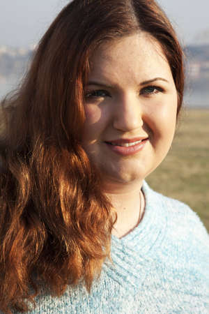A happy plus sized woman posing outdoors.の写真素材