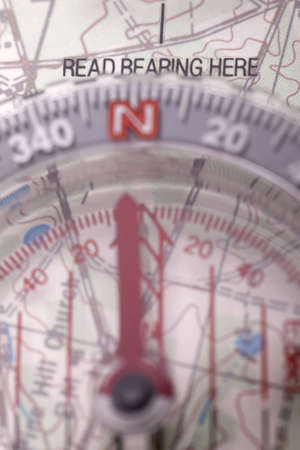 Closeup of a compass on a map, focused on where to read bearing.の写真素材