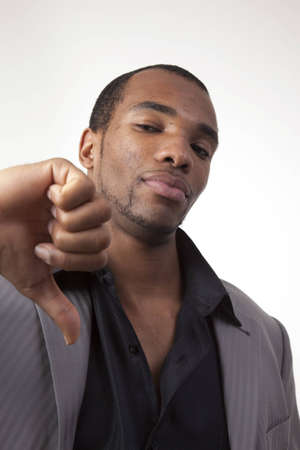 African american man in dress clothes giving a thumbs down signの写真素材