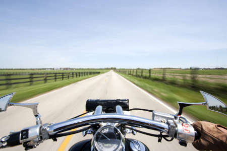 Shot from rider perspective of a motorcycle cruising down a small country lane.の写真素材