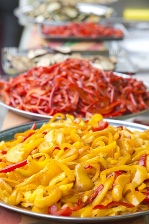 Red and yellow peppers in iron platesの写真素材