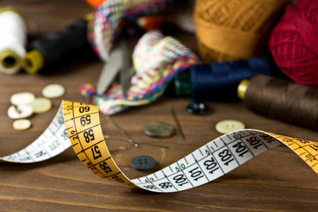 Sewing tools on a wooden background