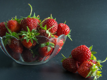 fresh red strawberries in a bowl on blackの写真素材