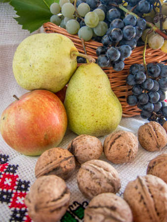 autumn harvest  of grapes walnuts pears and apples on a traditional romanian towelの写真素材