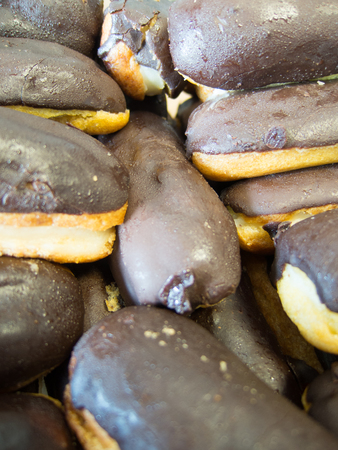 mini vanilla eclairs with chocolate frosting close up