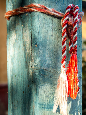 red and white martisor cord tied to house poleの写真素材