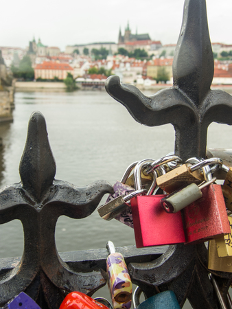 love padlocks on the bridge near vltava river prague with saint vitus cathedral in the backgroundの写真素材