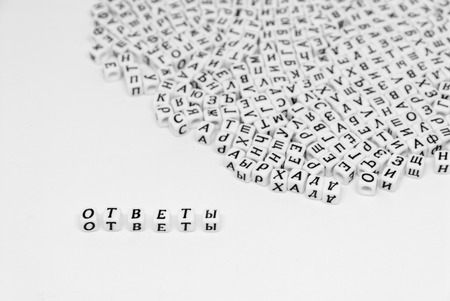 scattered cyrillic letters on white background and word answers written in cyrillic black and white photoの写真素材