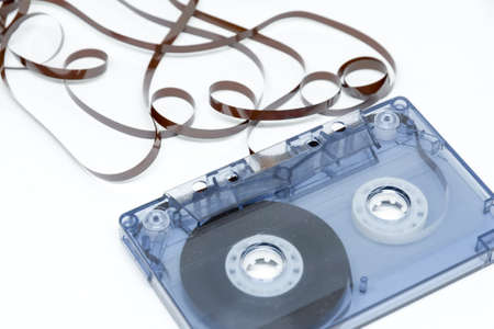 audio cassette with tape out on white background conceptual