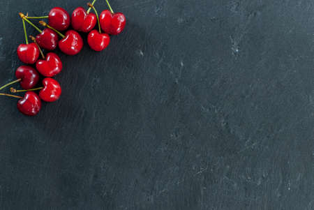 cherries arranges as a frame on black with copy spaceの写真素材
