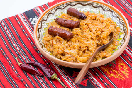 stewed cabbage and pork sausage served on a rustic decor with hot pepperの写真素材