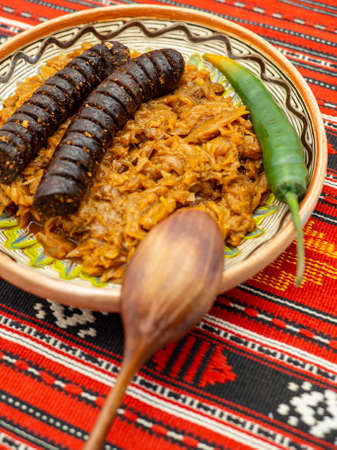 stewed cabbage and pork sausage served on a rustic decor with hot pepperの写真素材