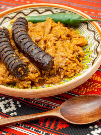 stewed cabbage and pork sausage served on a rustic decor with hot pepperの写真素材