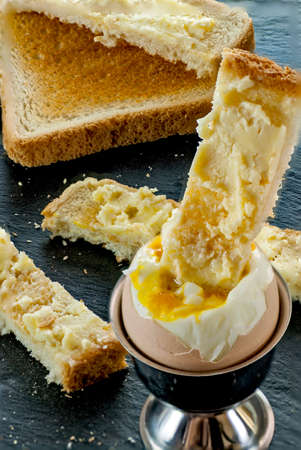 soft boiled egg and toast bread slice with butter breakfast concept