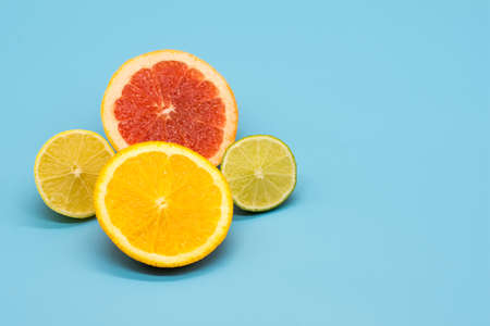 various citrus slices of orange lime lemon and grapefruit arranged on colorful background abstract...