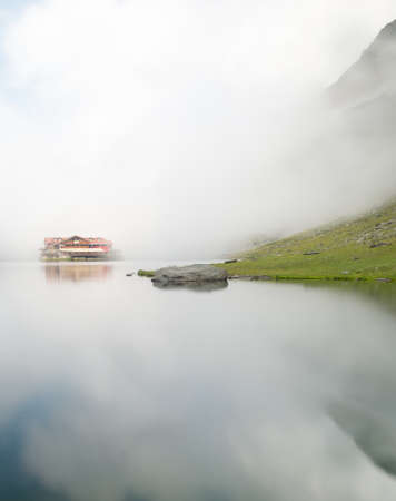 fog rising over balea chalet, transfagarasan road, romaniaの写真素材