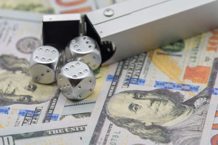 silver dices over hundred dollars bills gaming gambling stock exchange conceptの写真素材