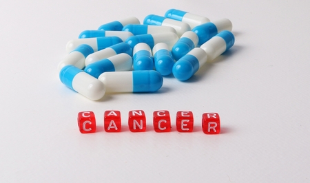 tablets and capsules lying in the studio with red dices with letters