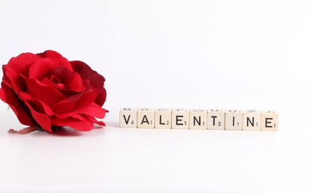 red ros is lying by dices with letters valentines dayの写真素材