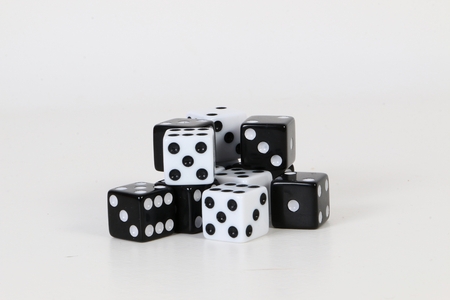 A heap of black and white dices are lying in the studioの写真素材