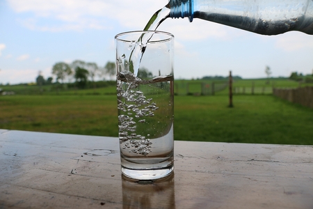 fresh water is falling in a glass on the tableの写真素材