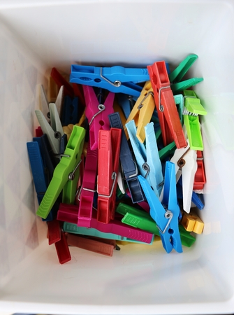 Heap of colorful clothespins are lying in a boxの写真素材