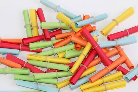 Heap of colorful tombola tickets are lying in the white studioの写真素材