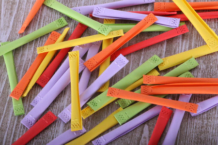 close up of a heap of colorful tombola tickets are lying on a wooden tableの写真素材