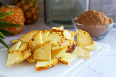 sliced pineapple on cutting board with whole freshly harvested pineapple.の写真素材