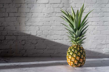 ripe pineapple on white table  background.
