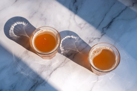 Two glass of homemade Kombucha on the marble table, fermented tea beverages in the sunlight.の写真素材
