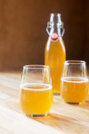 Two glass of homemade Kombucha on the marble table, fermented tea beverages in the sunlight.の写真素材