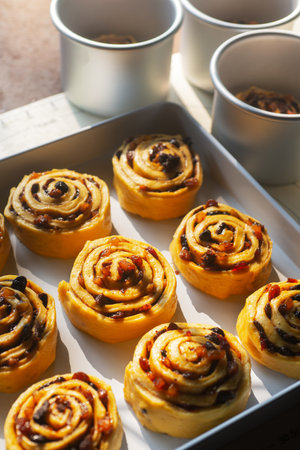 Uncooked mixed fruit cinnamon rolls dough on a baking tray in preparation for bakingの写真素材