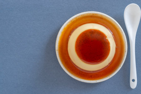 Top view of a cup of coffee with a spoon on a gray background