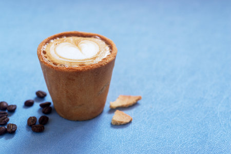 Cafe latte in edible cookie coffee cup, eco friendly alternative for takeaway cup.