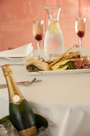 pastry crackers entree with roast beef,prosciutto,rocket and salami and champagne in ice bucketの写真素材