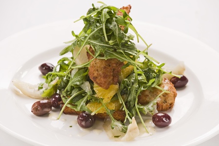 crumbed chicken with rocket,orange,onion and olivesの写真素材