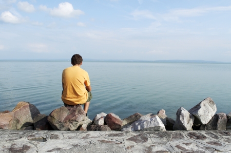 Teenager is sitting alone at Lake Balaton,Hungaryの写真素材