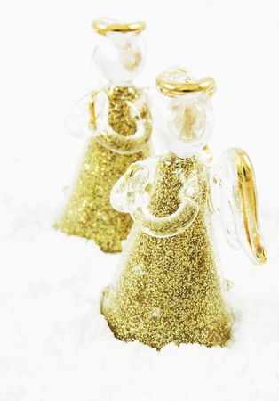 Golden glass angels in snow の写真素材