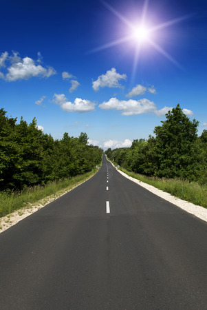 Straight main road leads across the forestの写真素材