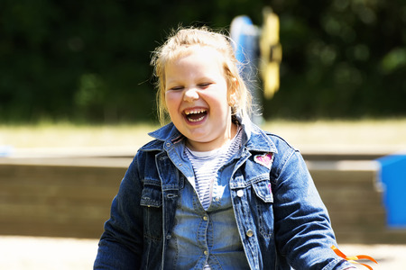 Happy little girl at playgroundの写真素材